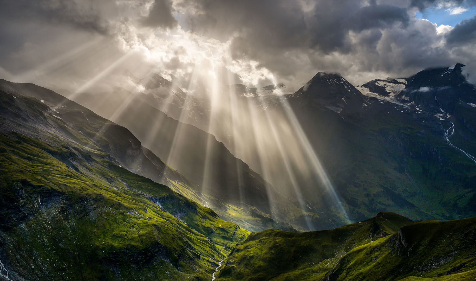 Dunkle Wolken, durchbrochen von Sonne in den Bergen