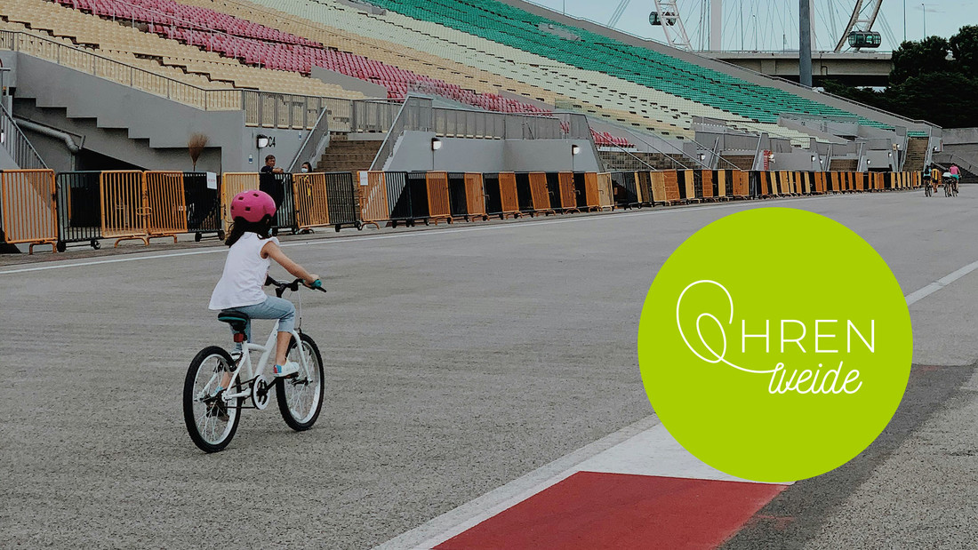 Ein kleines Mädchen fährt in einem leeren Stadion Fahrrad