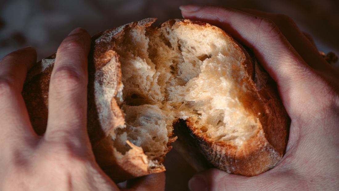 Brot wird Händen zerteilt