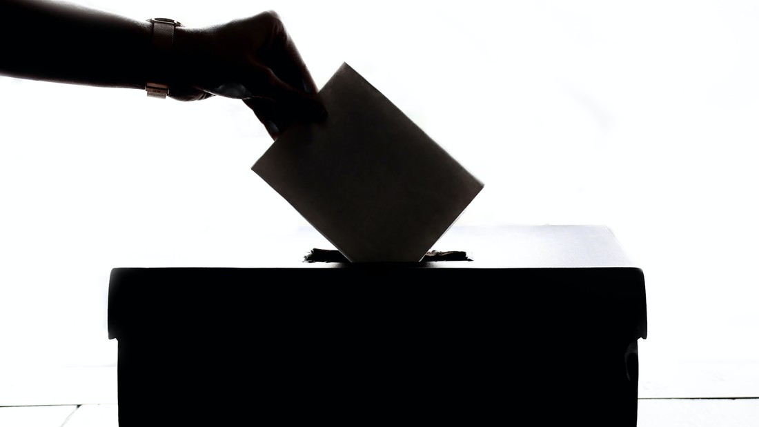 Symbolbild: Hand steckt Wahlzettel in die Urne