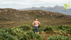 Ein Mann steht mit dem Rücken zur Kamera und betrachtet die Landschaft.