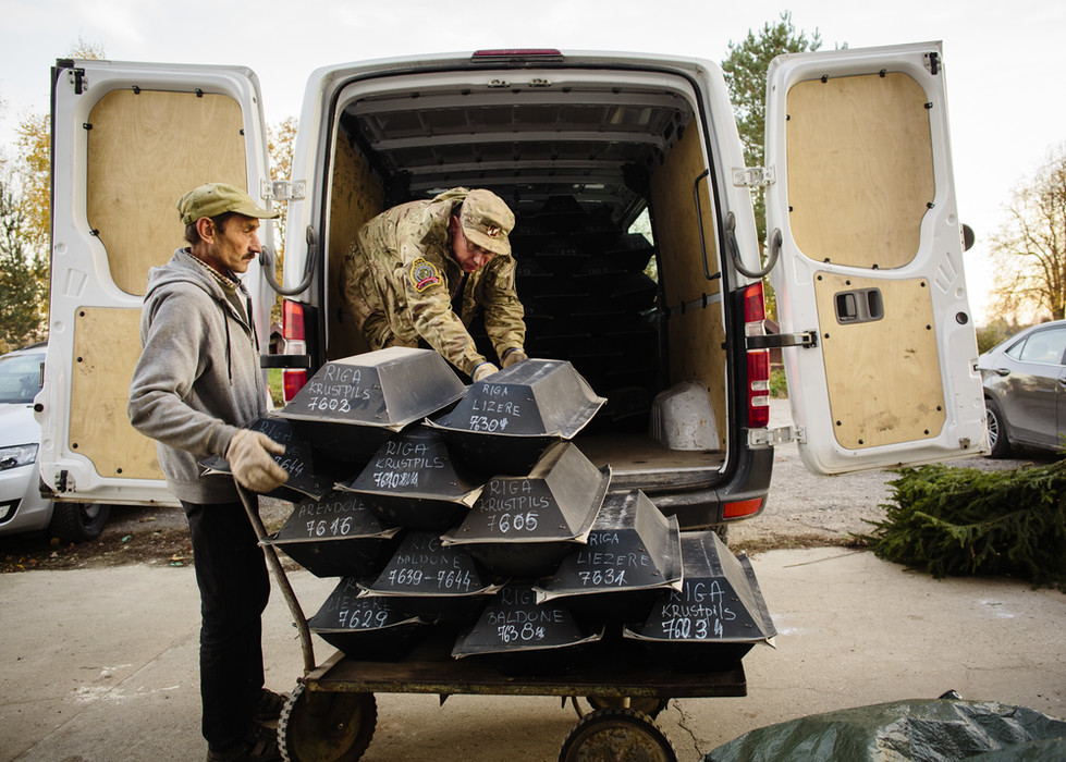 Helfer beim Verladen der Pappsärge