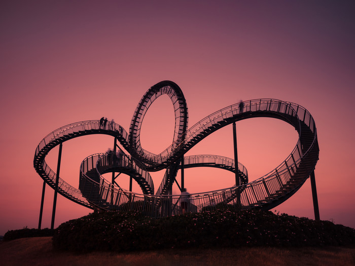 Gebogene Stahltreppe vor rotem Abendhimmel, Langzeitbelichtung