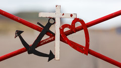Anker, Kreuz und Herz aus Eisen an einem Tor