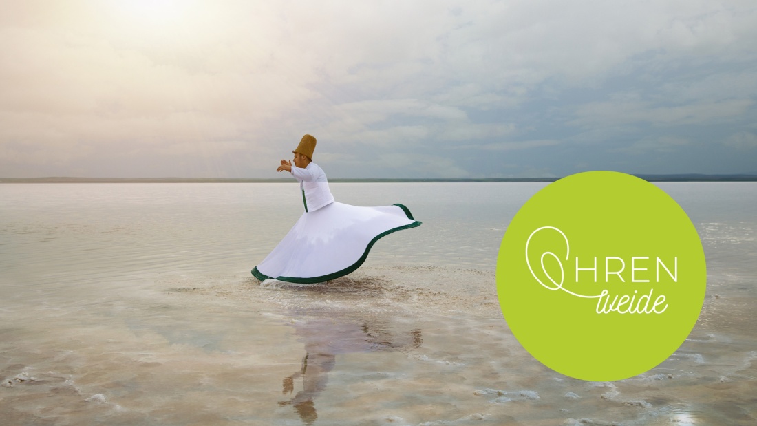 Sufi tanzt mit wehendem weißen Rock im flachen Meer