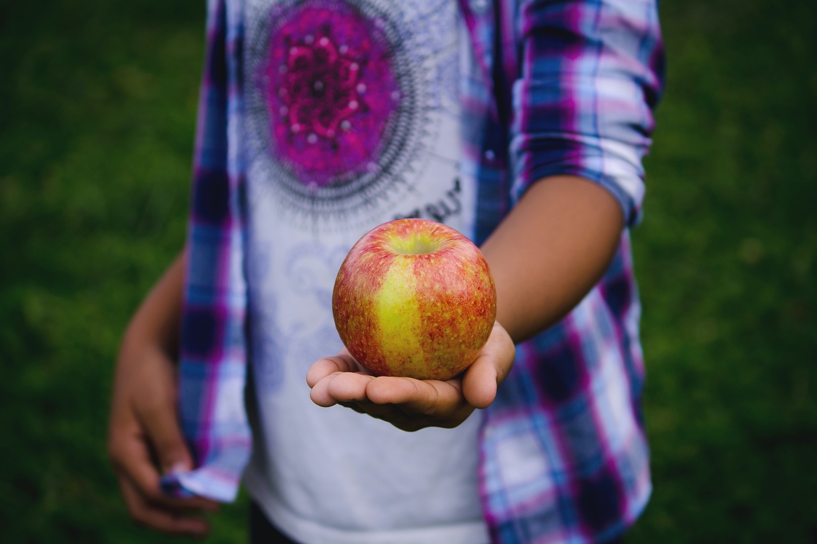 Teenager hält Apfel