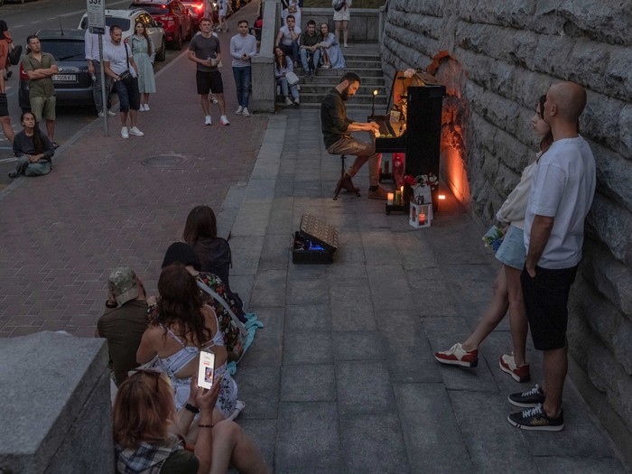 A street musician plays the piano during a partial electricity blackout in Kyiv 