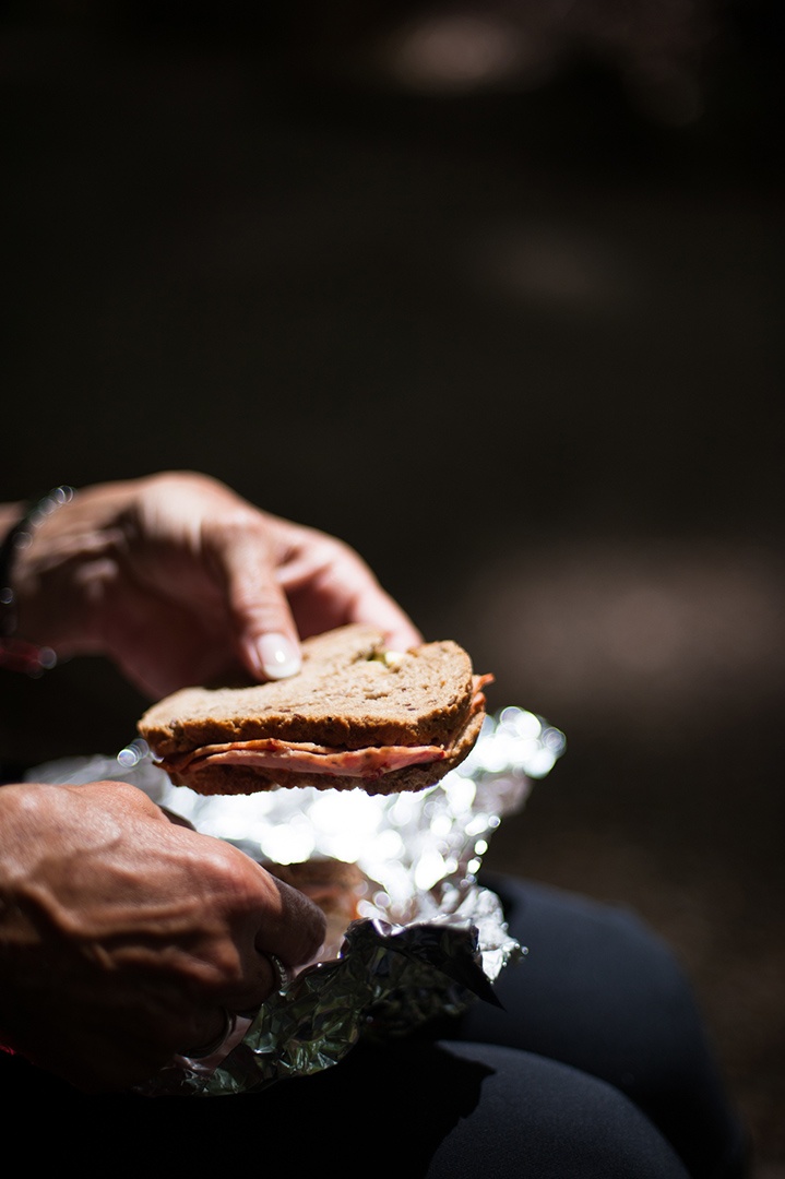 Eine Person hält ein mit Wurst belegtes Brot in der Hand