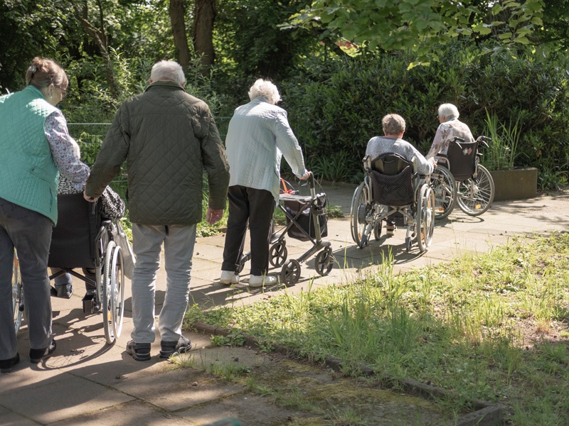 Alt und jung läuft durch den Park zurück zum Heim