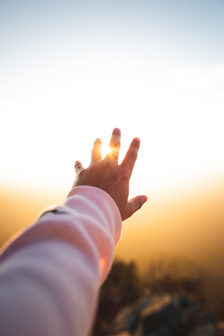 Hand greift nach Himmel