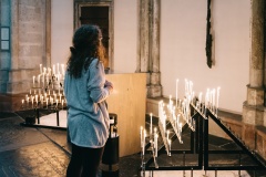 Eine junge Frau betet in einer Kirche.