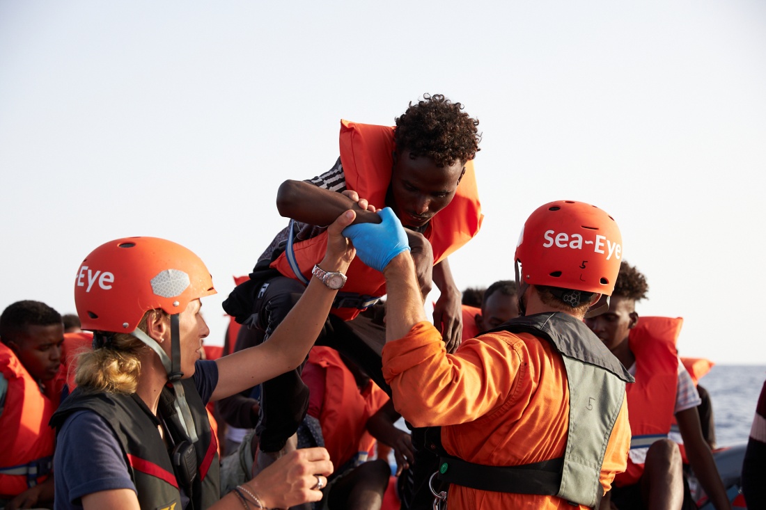 05.07.2019, ---, Mittelmeer: Die von der Seenotrettungsorganisation Sea-Eye herausgegebene Aufnahme zeigt Seenotretter die Flüchtlinge von einem Schlauchboot evakuiren. 