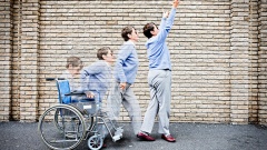 Symbolbild: Eine Frau im Rollstuhl lernt wieder laufen. Physiotherapie kann dies unterstützend möglich machen.