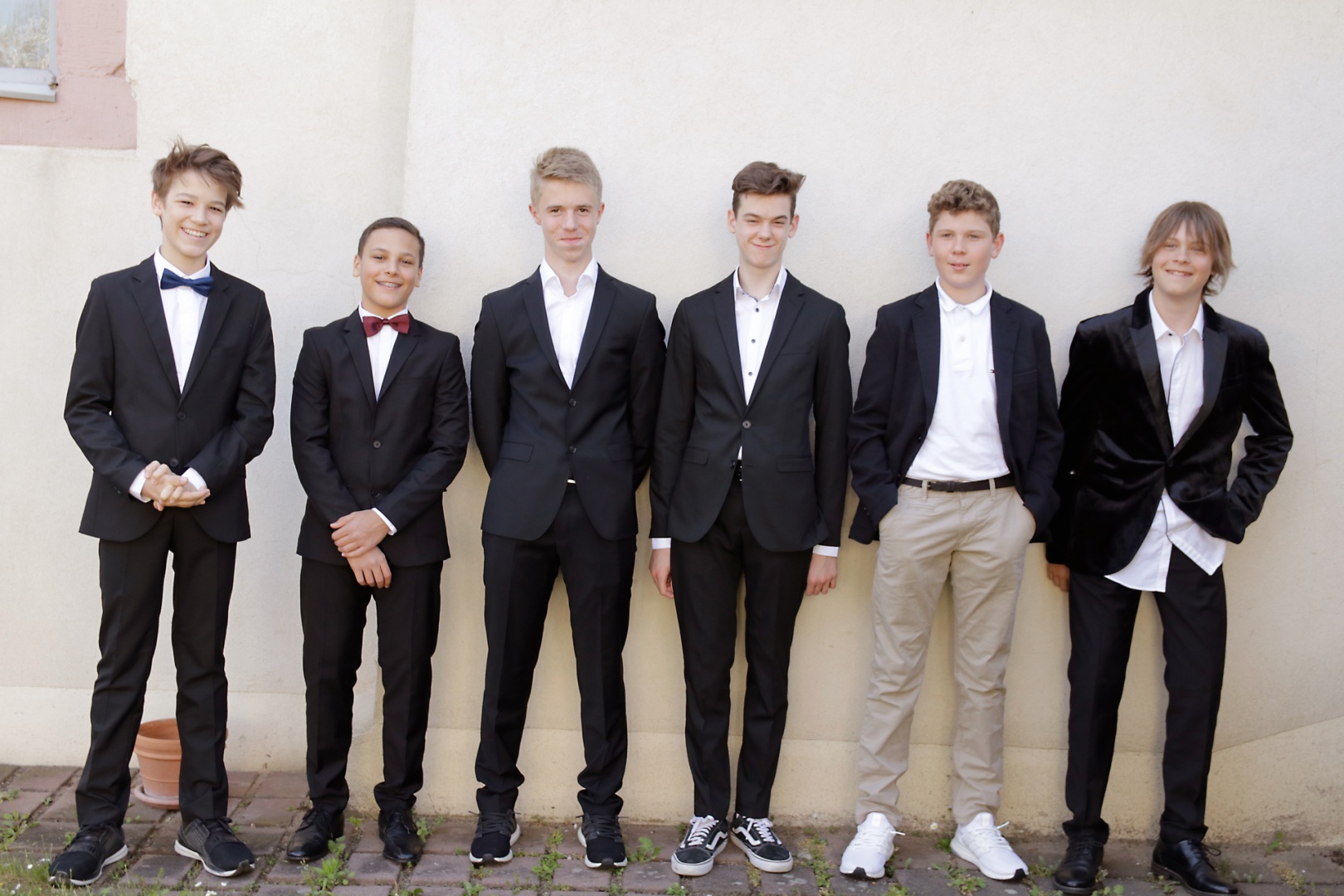 Die sechs Jungs sind vorwiegend klassisch in schwarz und weiß zu ihrer Konfirmation gekleidet