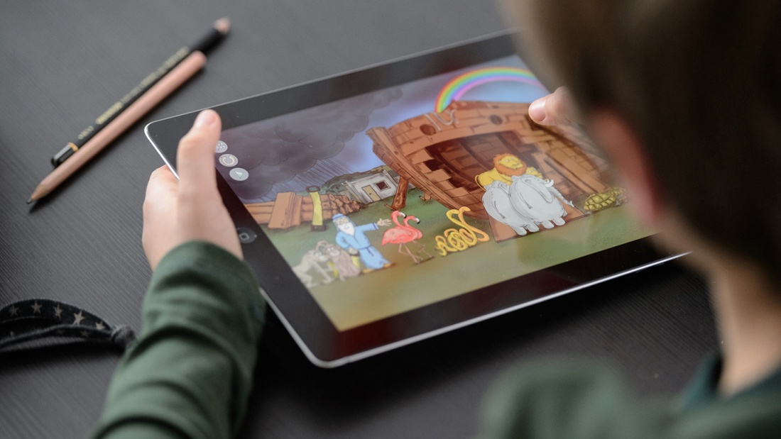 Der neunjährige Leander benutzt auf einem Tablet-Computer die Bibel-App "Spielbibel" von Miklos Geyer
