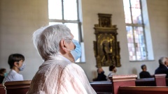 Gottesdienst in Zeiten der Corona-Pandemie: Menschen sitzen mit Masken und auf Abstand auf den Kirchenbänken