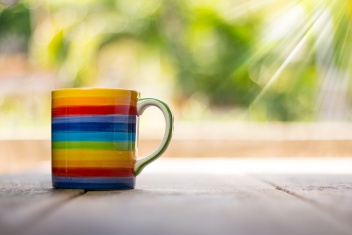 Tasse in Regenbogenfarben auf Tisch