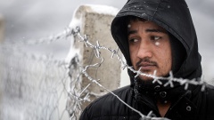 Migrant steht an einem Zaun im Flüchtlingslager Lipa