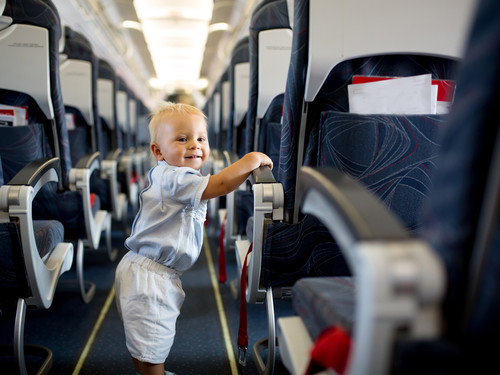 Kleiner Junge im Flugzeug nimmt Kontakt auf zu anderen Passagieren