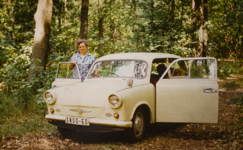 Frau mit hellem Auto in Wald