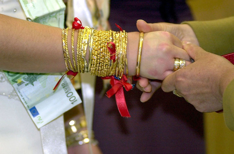 Ein Brautpaar nimmt bei einer türkischen Hochzeit mit mehr als 1.000 Gästen in Köln Geschenke entgegen: Die Braut erhält meist Goldschmuck, dem Bräutigam wird Geld angeheftet.