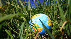 Ein kleiner Globus liegt im Gras.