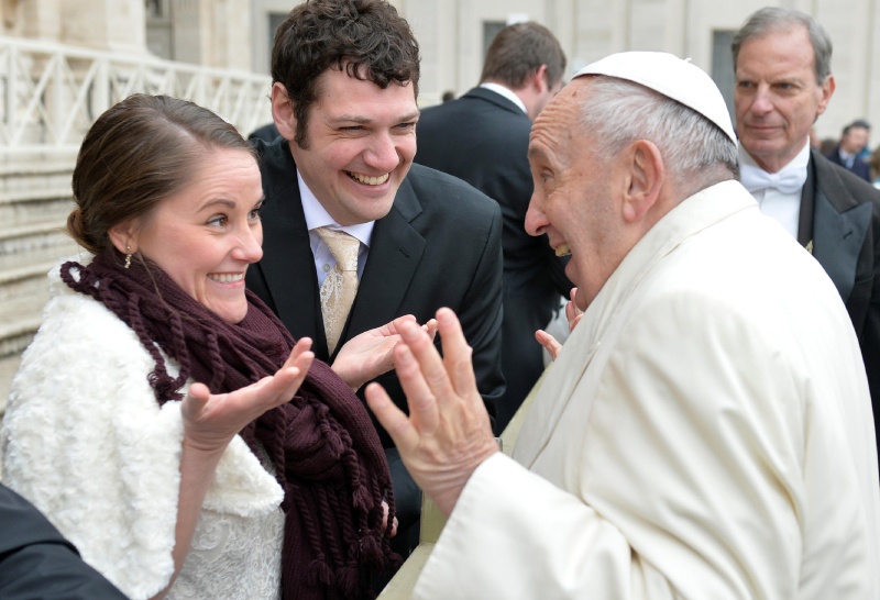 Papst Franziskus scherzt mit einem Ehepaar.