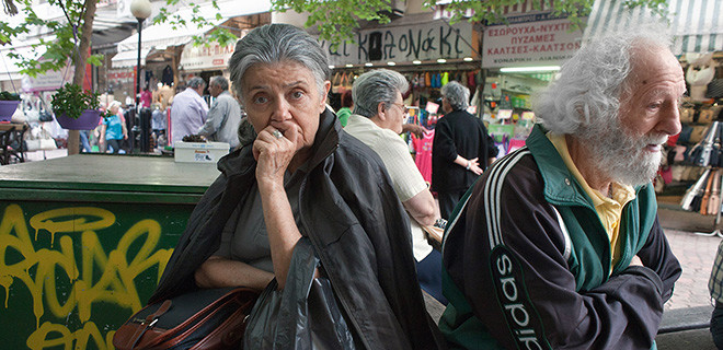 Besorgte Rentner sitzen auf einer Bank in Athen