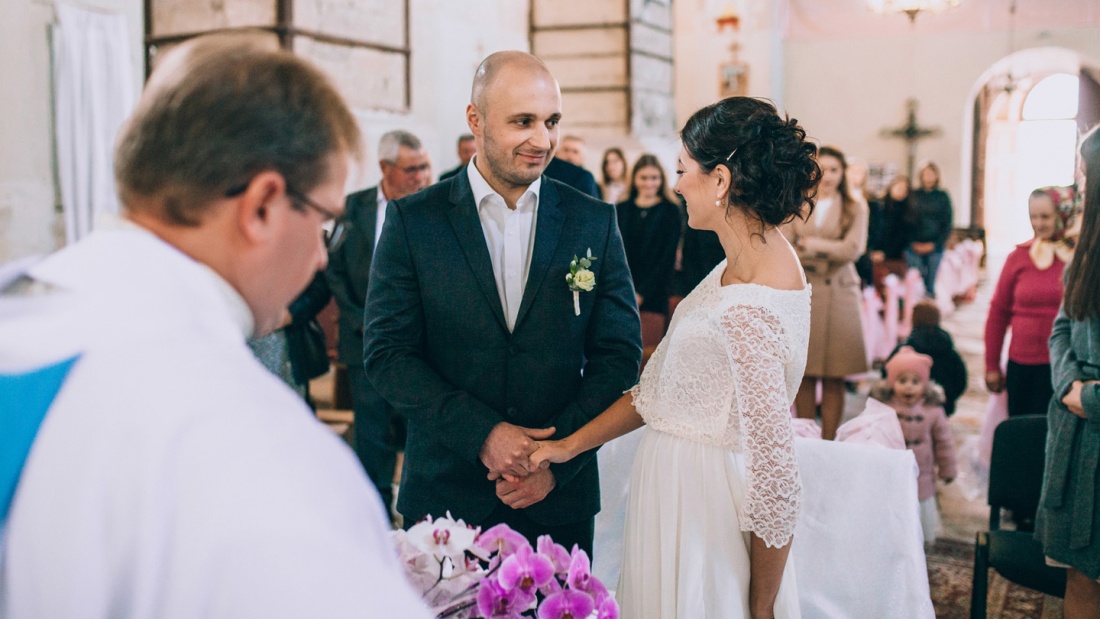 Ein junges Paar heiratet in Anwesenheit von Familie und Freunden in einer Kirche