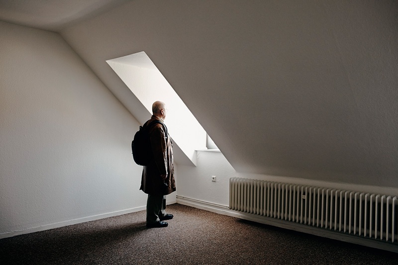 Herr B. steht in seiner leeren Wohnung.