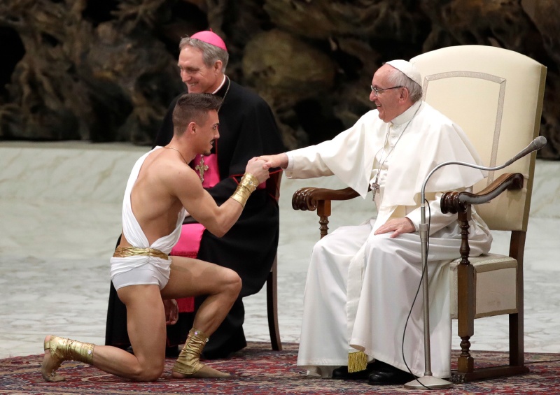 Ein Artist küsst die Hand des Papstes.