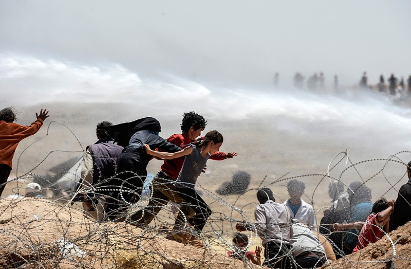 Kinder versuchen vor den Gefechten zwischen kurdischen Kämpfern und den Terroristen des IS bei der syrischen Stadt Tal Abyad in die Türkei zu fliehen. 