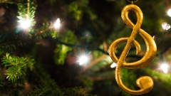 Ein goldener Notenschlüssel hängt an einem Christbaum.