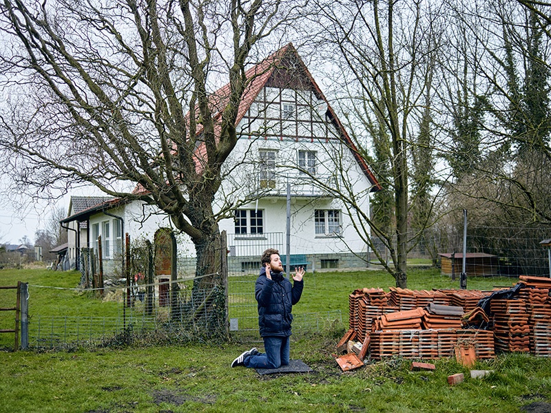 Ein Mann kniet auf einer Wiese in Verne und betet.