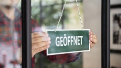 Schild "Laden geöffnet" wird aufgehängt