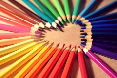 Herz aus verschieden farbigen Buntstiften.