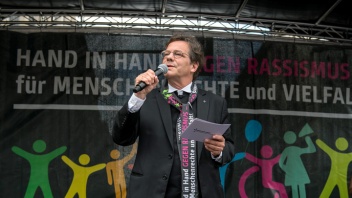 Markus Dröge spricht bei der Auftaktkundgebung zu einer Menschenkette gegen Rassismus in Berlin. 