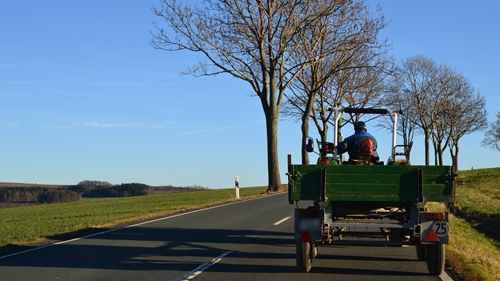 Ein Traktor fährt auf einer Bundesstraße.