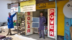 Frank Evans mit Solarzellen vor seinem Elektronikladen an der Strasse von Arusha nach Moshi im Norden von Tansania.