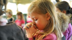 Ins Gebet versunkenes Mädchen in der evangelischen Kindertagesstätte Knesebeck, Nidersachsen