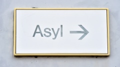 Ein Schild mit der Aufschrift "Asyl" hängt in der Landeserstaufnahme für Asylbewerber (LEA) in Karlsruhe an einer Wand.