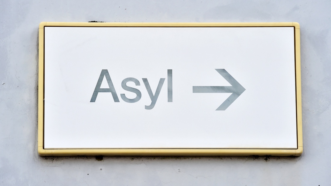 Ein Schild mit der Aufschrift "Asyl" hängt in der Landeserstaufnahme für Asylbewerber (LEA) in Karlsruhe an einer Wand.