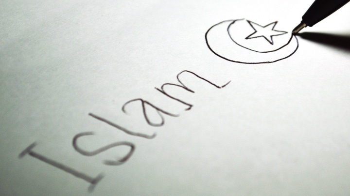 Das Wort "Islam" steht neben einer gezeichneten Mondsichel und einem fünfzackigem Stern auf einem Blatt Papier.