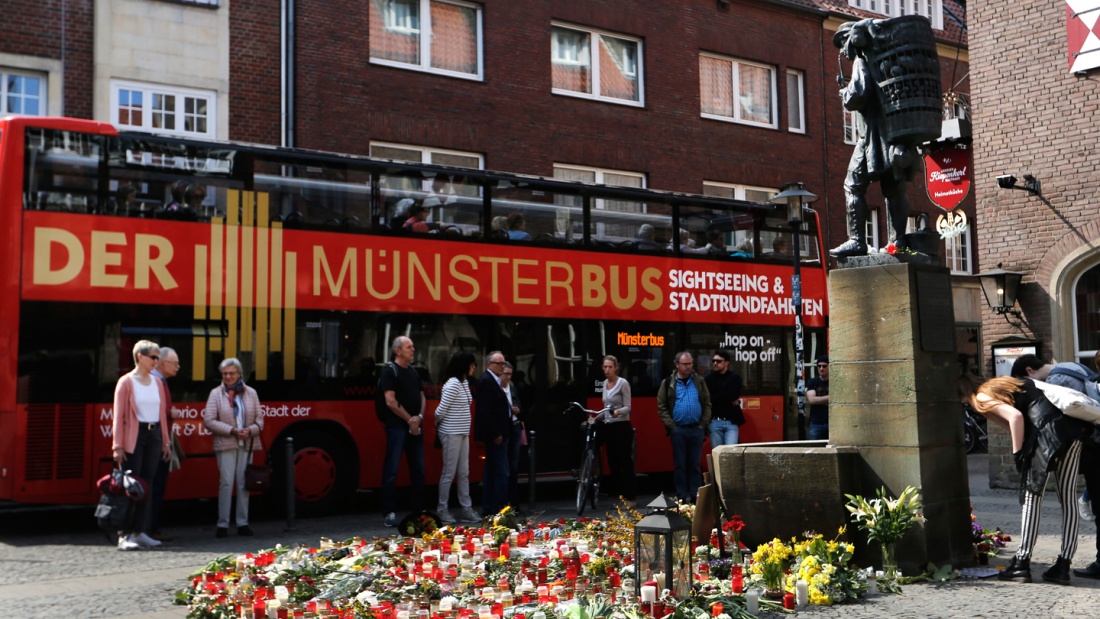 Ein Tourismus-Bus fährt an der Statue "Kiepenkerl" vorbei.