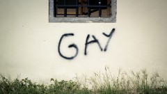 Graffito "Gay" an einer Hauswand.