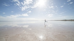 Person springt auf einem Salzsee in die Luft
