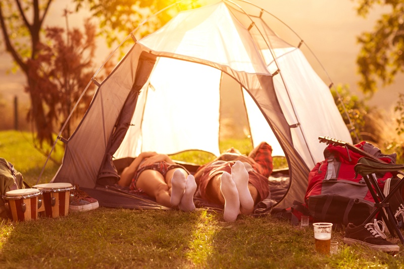 Ein Pärchen schläft in einem Zelt, während langsam die Sonne aufgehtelten