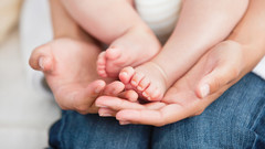 Nahaufnahme eines Babys auf dem Schoß der Mutter.