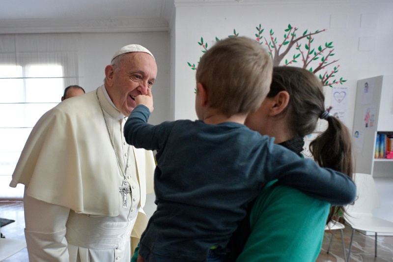 Papst Franziskus unterhält sich mit einer Gefängnisinsassin und ihrem Kind.