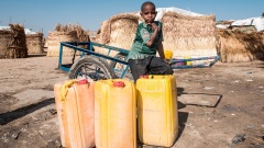 In Maiduguri in Nigeria sammeln Menschen an einem öffentlichen Bohrloch ihr Wasser. Sie sind vor der Gewalt Boko Harams aus ihren Dörfern geflohen. Ein Junge steht hinter Wasserkanistern.